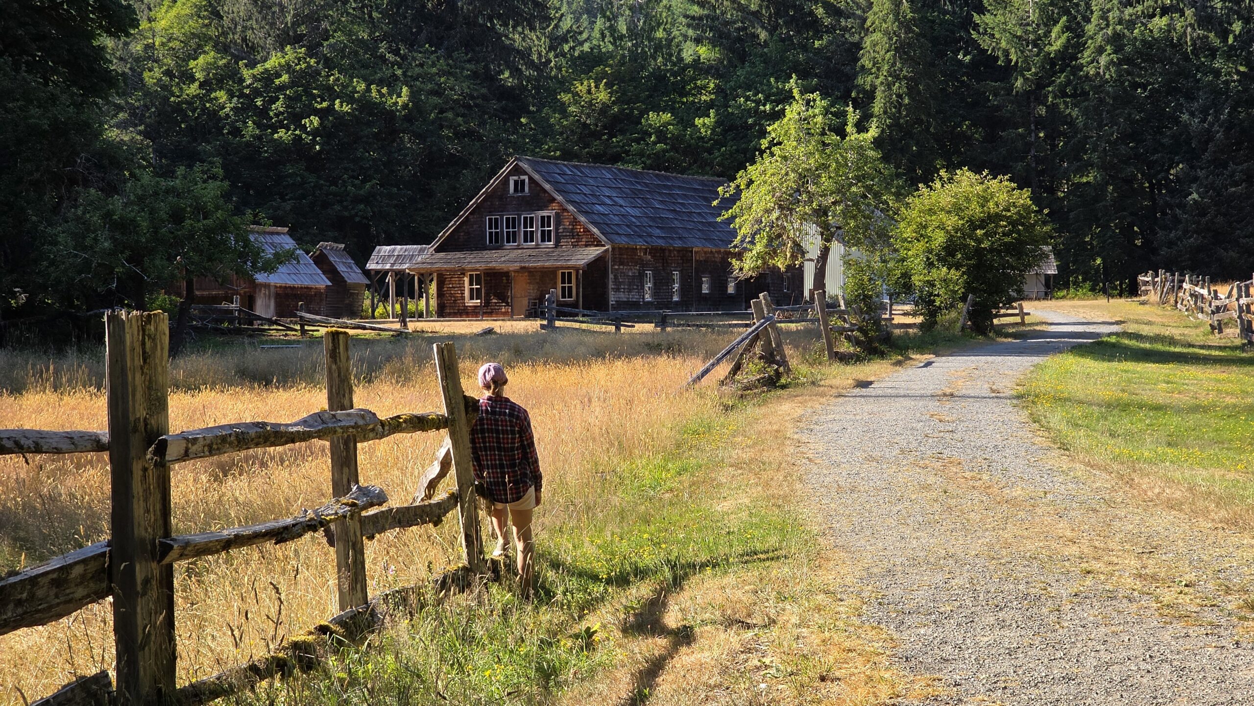 Spacer po Maple Glade Nature Trail w Olympic National Park – ja stojąca na łące, oparta o drewniany płot i patrząca na opuszczoną farmę w otoczeniu natury